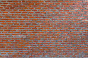 Red brick wall background with uneven texture and varying brick sizes. photo