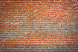 Red brick wall background with uneven texture and varying brick sizes. photo