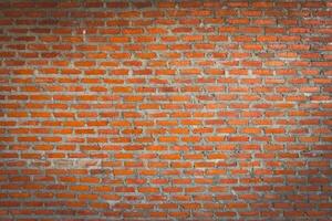 Red brick wall background with uneven texture and varying brick sizes. photo