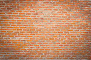Red brick wall background with uneven texture and varying brick sizes. photo