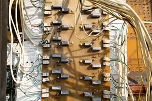 A tangled mess of wires and cords. The wires are all different colors and lengths. Concept of chaos and disorganization photo