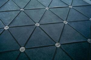 A black tile floor with a diamond pattern. The tiles are square and black. The floor is made of a material that is not visible photo