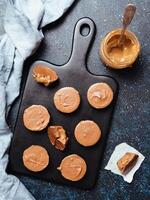 Stack of vegan chocolate cups with caramel on white photo