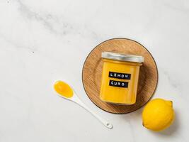 Homemade lemon curd in jar, top view, vertical photo