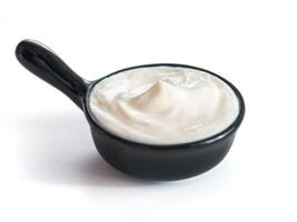 Beautiful greek yogurt or sour cream in black bowl, isolated on white background with clipping path. Copy space for text photo