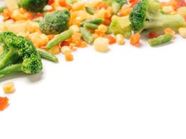 Frozen vegetables assorted isolated on white with clipping path. Frosen vegetables with ice Isolated one edge. Frozen mix vegetables with copy space for text. photo
