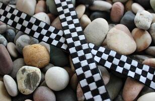 Fabric Crisscross Racing Checkered Stripe On Decorative Rocks Closeup View photo