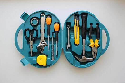 Pliers, mounting knife, scissors, electrical tape, voltage tester, tape measure, wrenches and screwdrivers in a toolbox top view photo