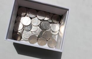Ukrainian coins denomination 1 and 2 hryvnia in a cardboard box studio isolated stock photo