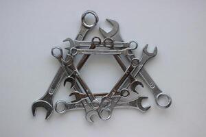 Geometrically laid out in a triangular shape, chrome plated wrenches of different sizes photo
