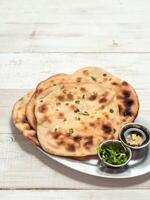 naan flatbreads on white wood, copy space, vertical photo