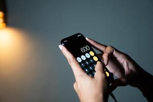 Hands using smart phone calculator photo