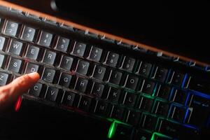 Finger pressing ID key on dusty backlit keyboard photo