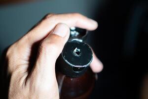 Hand holding an open bottle cap with a small hole photo