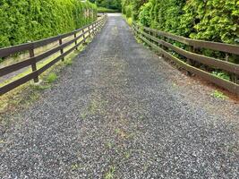 Made of gravel road and bordered by a fence for the driveway to the houseMade of gravel road and bordered by a fence for the driveway to the house photo