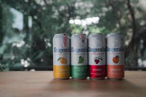Samut Prakan, Thailand - July 10 A popular Hoegaarden beer four flavors include Yuzu, Shine muscat grape, Rosee, and peach put on wood table photo