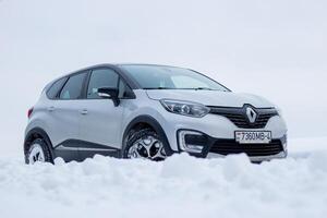 Grodno, Belarus-01.31.2021 Renault Kaptur or Renault Captur SUV on a winter road against the background of a field and forest. Winter driving conditions in Renault on a snowy road photo