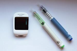 Poznan, Poland - 10.20.2022 Accu-Chek Instant glucose meter with toujeo long insulin and apidra short insulin photo