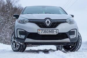 Grodno, Belarus-01.31.2021 Renault Kaptur or Renault Captur SUV on a winter road against the background of a field and forest. Winter driving conditions in Renault on a snowy road photo
