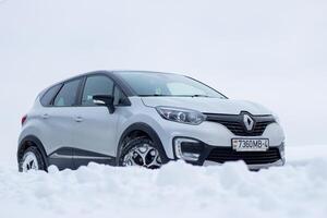 Grodno, Belarus-01.31.2021 Renault Kaptur or Renault Captur SUV on a winter road against the background of a field and forest. Winter driving conditions in Renault on a snowy road photo