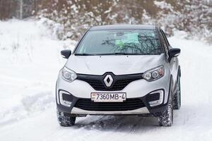 Grodno, Belarus-01.31.2021 Renault Kaptur or Renault Captur SUV on a winter road against the background of a field and forest. Winter driving conditions in Renault on a snowy road photo