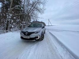 Grodno, Belarus-01.31.2021 Renault Kaptur or Renault Captur SUV on a winter road against the background of a field and forest. Winter driving conditions in Renault on a snowy road photo
