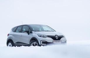 Grodno, Belarus-01.31.2021 Renault Kaptur or Renault Captur SUV on a winter road against the background of a field and forest. Winter driving conditions in Renault on a snowy road photo