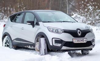 Grodno, Belarus-01.31.2021 Renault Kaptur or Renault Captur SUV on a winter road against the background of a field and forest. Winter driving conditions in Renault on a snowy road photo