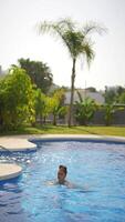 uma homem é casualmente desfrutando ele mesmo dentro uma natação piscina debaixo a brilhante Sol em uma lindo dia video