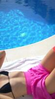 Relaxing by the pool, enjoying a view of blue water and warm sunlight for carefree relaxation video