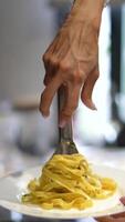 A plate of fettuccine pasta, elegantly served with utensils, is appealing and appetizing video
