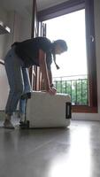 Capture a Moment of a Person Packing a Suitcase in a Modern Room with the Balcony Door Wide Open video