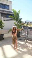 A woman is having a relaxing time on the patio in the summer, enjoying a cool drink video
