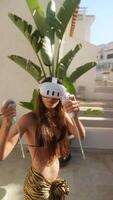 Child playing virtual reality game outside on patio with modern white building in background video