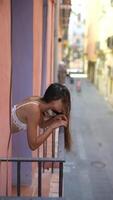 A woman is relaxing on a colorful balcony in an urban scene, enjoying the view and the serenity video