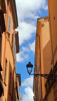 Charming alleyway under a blue sky with a traditional lamp adding to classic European architecture video