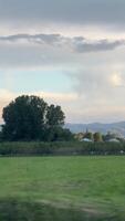 A serene orchard with distant mountains under a cloudy sky, offering a tranquil view video