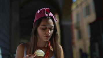 A young woman wearing a pink cap is relaxing outdoors in a peaceful urban setting on a summer day video