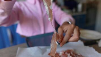 A CloseUp View of a Person Holding Fine Slices of Cured Meat on a Rustic Wooden Platter video