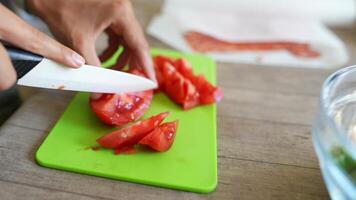 A ceramic knife slicing tomatoes on a cutting board demonstrates culinary skill and precision video