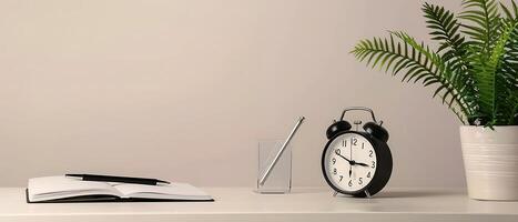 Minimalist Workspace White Desk with Notebook, Alarm Clock, and Potted Fern photo