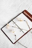 Blank pages of notebook and drying flowers. photo