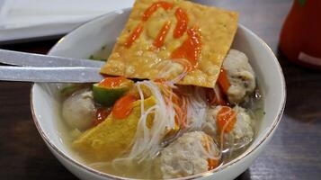 Bakso are Indonesian style soup dishes, meatballs served with vermicelli noodles, tofu and fried dumplings photo