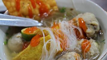 Bakso are Indonesian style soup dishes, meatballs served with vermicelli noodles, tofu and fried dumplings photo