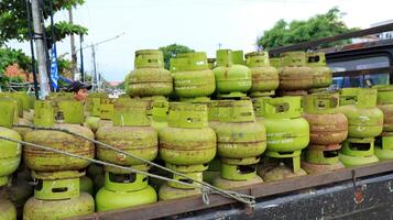 Stack of 3 kilo green gas cylinders, LPG photo