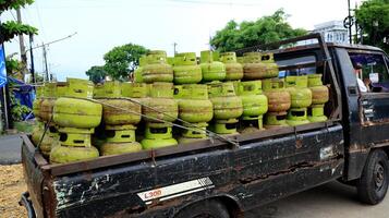 Stack of 3 kilo green gas cylinders, LPG photo