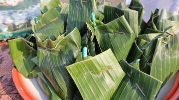 stack of traditional wrapped rice in banana leaves photo