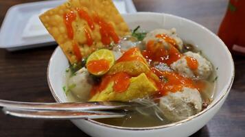 Bakso are Indonesian style soup dishes, meatballs served with vermicelli noodles, tofu and fried dumplings photo