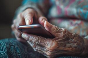 Close-up of elderly hands using a smartphone demonstrating technology adoption photo