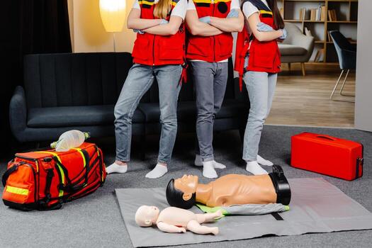Group of people with cpr dummy looking at camera and smiling after first aid training class photo